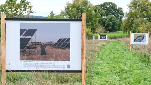 Large signboards in Tyntesfield's orchard as part of the Earth Photo 2026 exhibition
